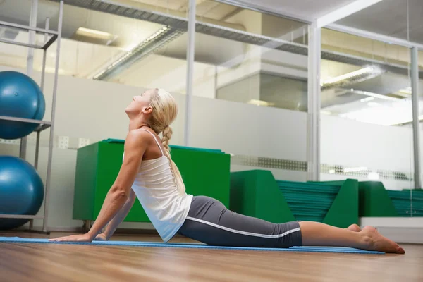 Sidovy av kvinnan sträcker sig tillbaka henne i fitnesstudio — Stockfoto