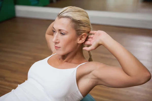 Mulher fazendo crunches abdominais na bola de fitness no ginásio — Fotografia de Stock