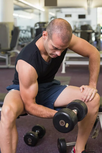 Joven haciendo ejercicio con la mancuerna en el gimnasio —  Fotos de Stock