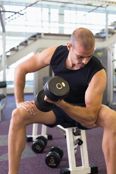 Junger Mann trainiert mit Hantel im Fitnessstudio — Stockfoto