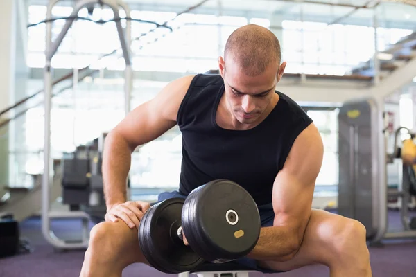 Young man exercising with dumbbell in gym — Stock Photo, Image