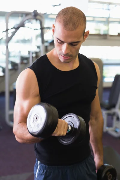 Young man exercising with dumbbell in gym — Stock Photo, Image