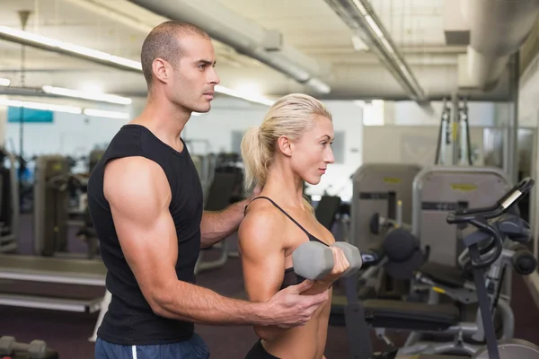 Erkek eğitmen içinde jimnastik salonu kadın dumbbell ile yardım — Stok fotoğraf