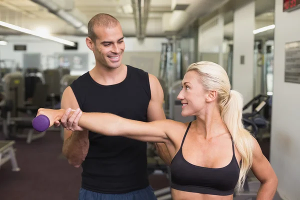 Erkek eğitmen içinde jimnastik salonu kadın dumbbell ile yardım — Stok fotoğraf