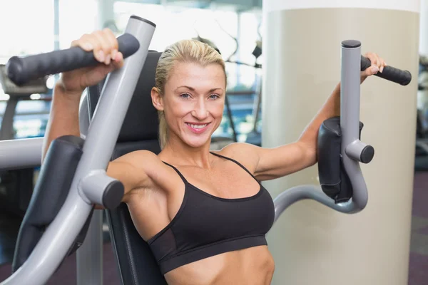 Fitte Frau nutzt Fitnessgerät im Fitnessstudio — Stockfoto
