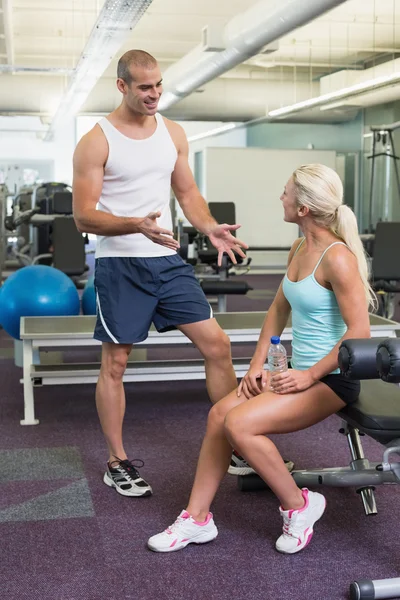 Mannelijke trainer talking to fit vrouw bij gym — Stockfoto