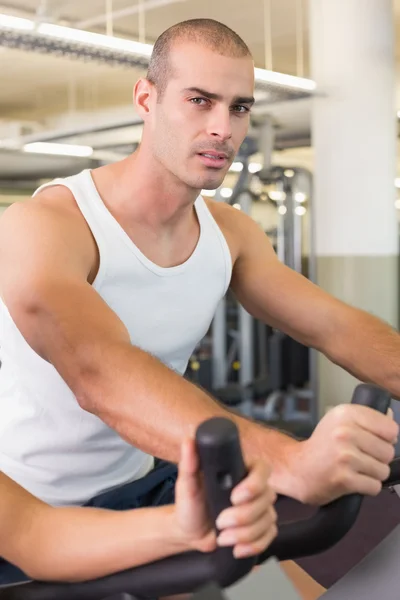 Man working out on exercise bike at gym — Stock Photo, Image