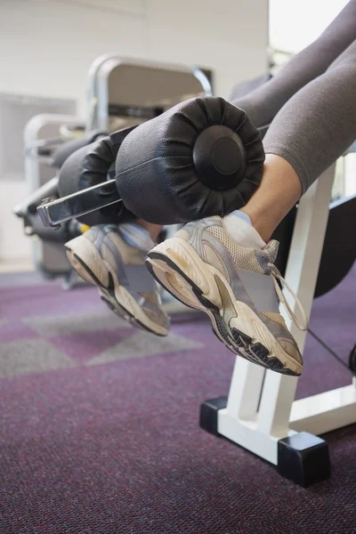 Fit woman using weights machine for legs — Stock Photo, Image