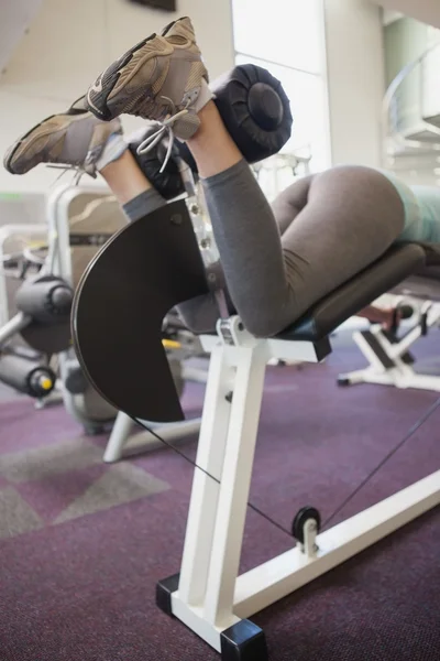 Fit woman using weights machine for legs — Stock Photo, Image