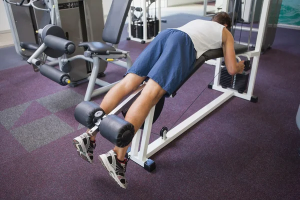 Ajuste el hombre usando la máquina de pesos para las piernas — Foto de Stock