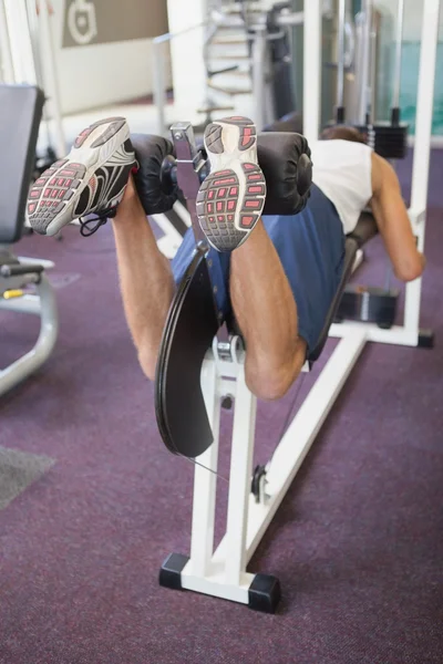 Passar man använder vikter maskin för ben — Stockfoto