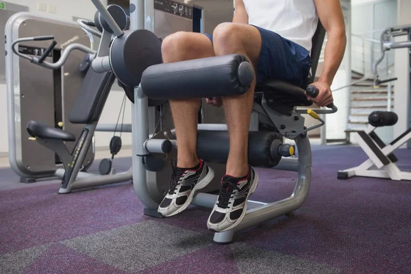Fit man using weights machine for legs — Stock Photo, Image