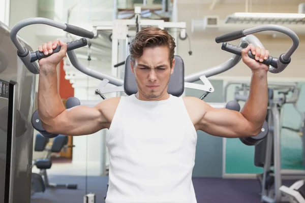 Fit man using weights machine for arms — Stock Photo, Image