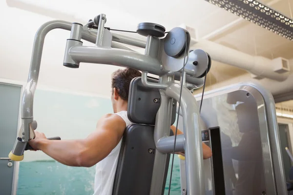 Fit man using weights machine for arms — Stock Photo, Image