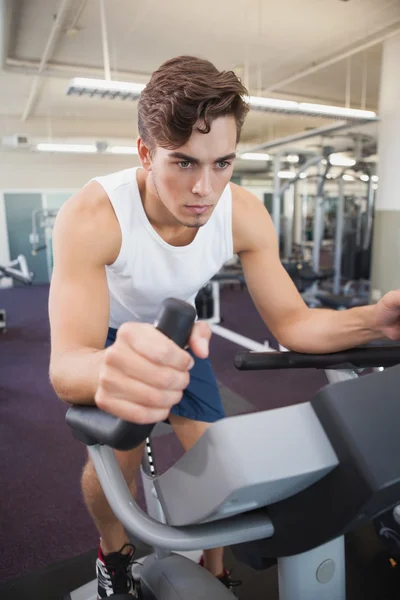 Hombre en forma haciendo ejercicio en la bicicleta estática —  Fotos de Stock