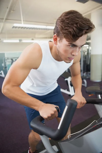 Fit man working out on the exercise bike — Stock Photo, Image