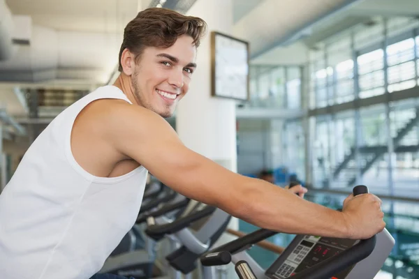 Hombre en forma haciendo ejercicio en la bicicleta estática — Foto de Stock