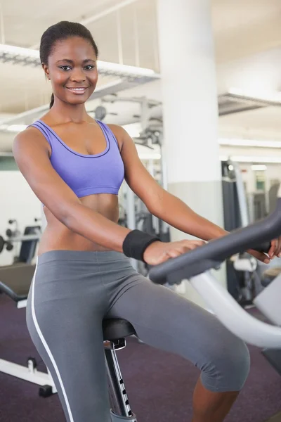 Fit woman working out on the exercise bike — Stock Photo, Image