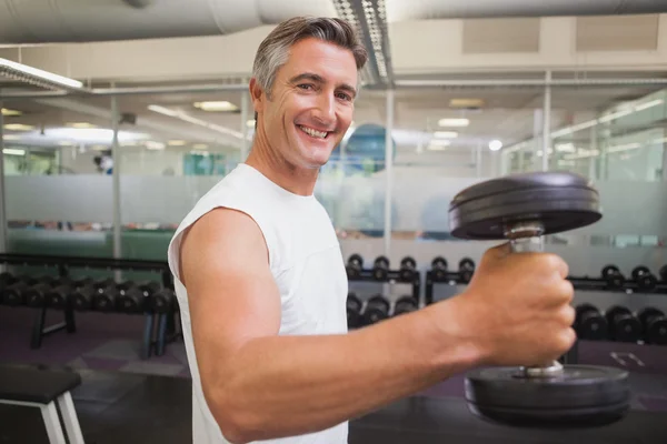 Fit man lifting heavy black dumbbell — Stock Photo, Image