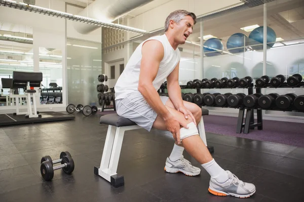 Skadade mannen gripande sitt knä i vikter rummet — Stockfoto