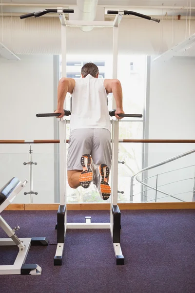 Fit man doing pull up in fitness studio — стоковое фото