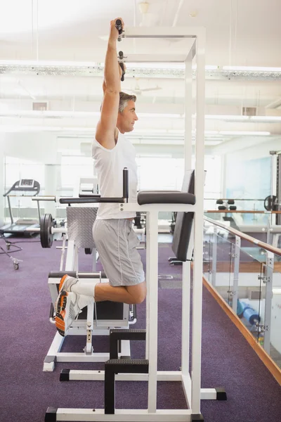 Fit man doing pull up in fitness studio — стоковое фото