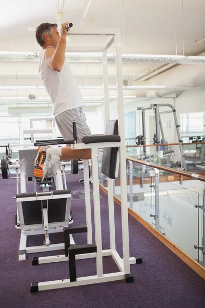 Fit man doing pull ups in fitness studio — Stock Photo, Image