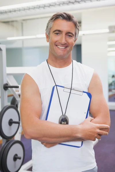 Entrenador personal que sonríe a la cámara en el gimnasio — Foto de Stock