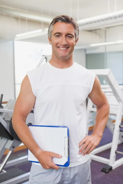 Adatta personal trainer sorridente alla fotocamera in sala fitness — Foto Stock