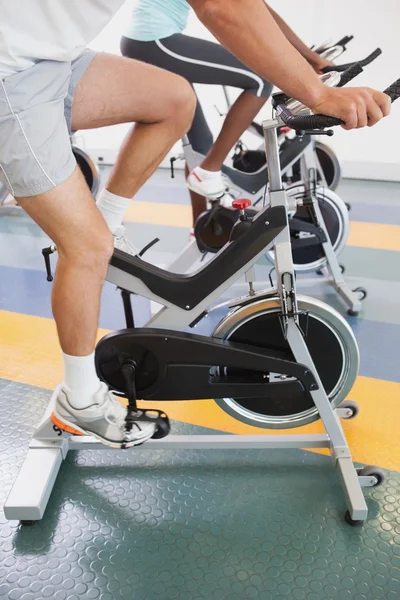 Fit people working out on the exercise bikes — Stock Photo, Image