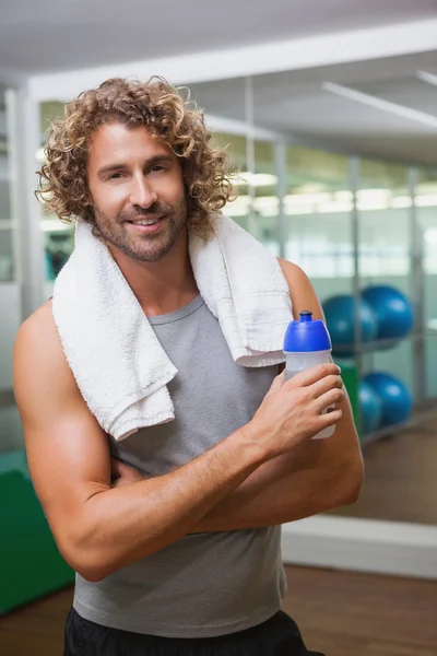 Smiling handsome man holding water bottle at gym Royalty Free Stock Images