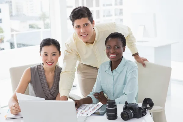 Casual business team looking at laptop together — Stock Photo, Image