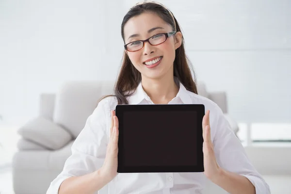 Businesswoman sitting and showing tablet — Stock Photo, Image