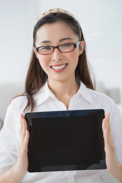 Businesswoman sitting and showing tablet — Stock Photo, Image