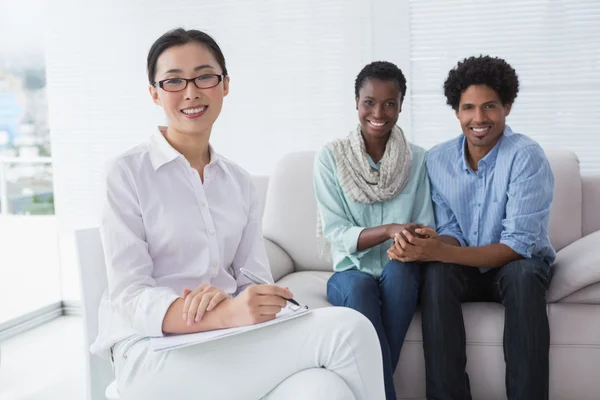 Reconciled couple smiling at camera with therapist — Stock Photo, Image