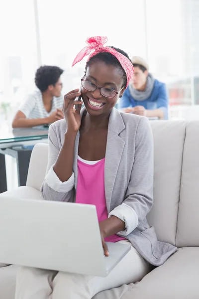 Young creative woman using laptop on couch — Stock Photo, Image