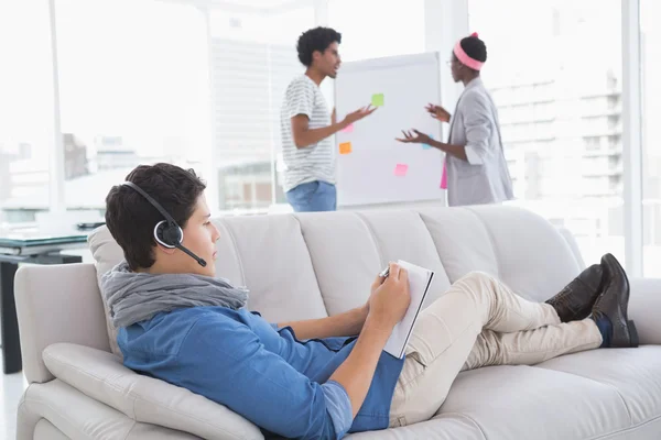 Jeune homme créatif utilisant un ordinateur portable sur le canapé — Photo