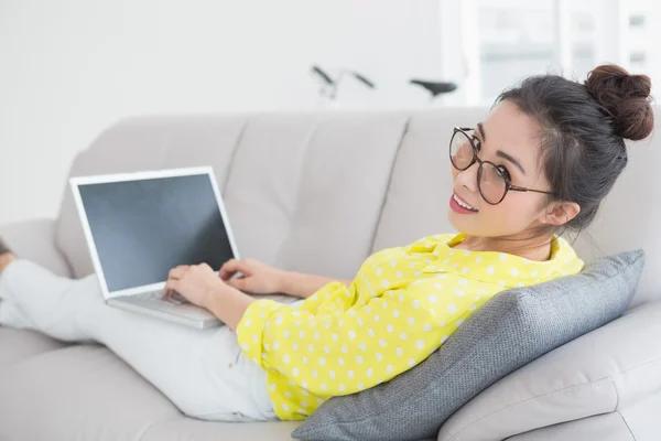 Νέα δημιουργική γυναίκα χρησιμοποιώντας φορητό υπολογιστή στον καναπέ — Φωτογραφία Αρχείου
