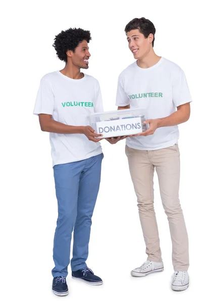 Jóvenes voluntarios sonrientes recogiendo donaciones —  Fotos de Stock