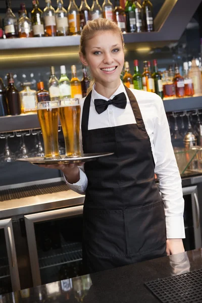 Söt servitris innehar en bricka med champagne — Stockfoto