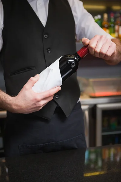 Garçom bonito abrindo uma garrafa de vinho tinto — Fotografia de Stock