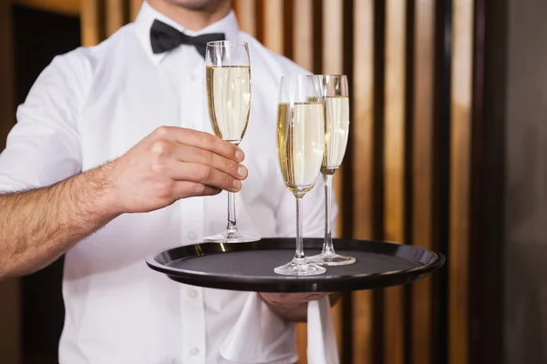 Garson holding tepsi şampanya — Stok fotoğraf