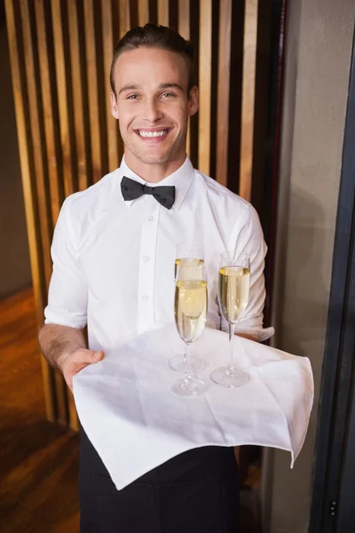 英俊的微笑服务员拿着托盘的香槟 — 图库照片