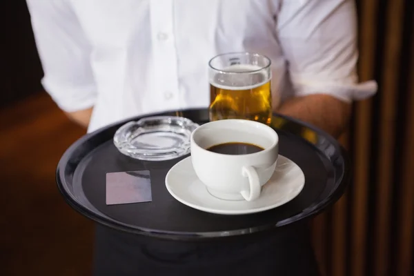 Kellner hält Tablett mit Kaffeetasse und Bier in der Hand — Stockfoto