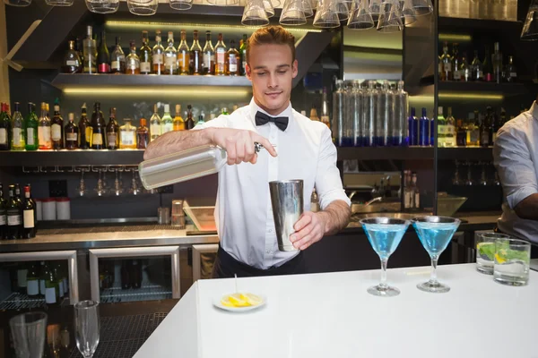 Lachende barman voorbereiding van een drankje in bar teller — Stockfoto