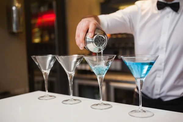 Barman gieten blauwe alcohol in cocktailglas — Stockfoto