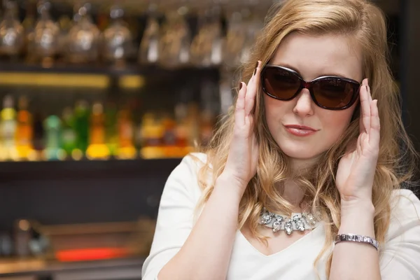 Jolie femme blonde en lunettes de soleil posant — Photo