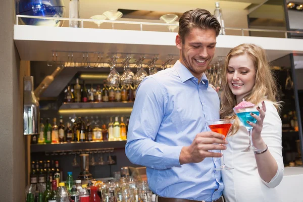 Cute couple standing and drinking cocktails — Stock Photo, Image