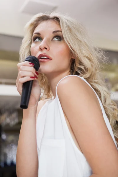 Pretty blonde woman singing while looking up — Stock Photo, Image