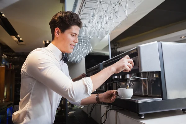 Lächelnder junger Barista kocht Tasse Kaffee — Stockfoto